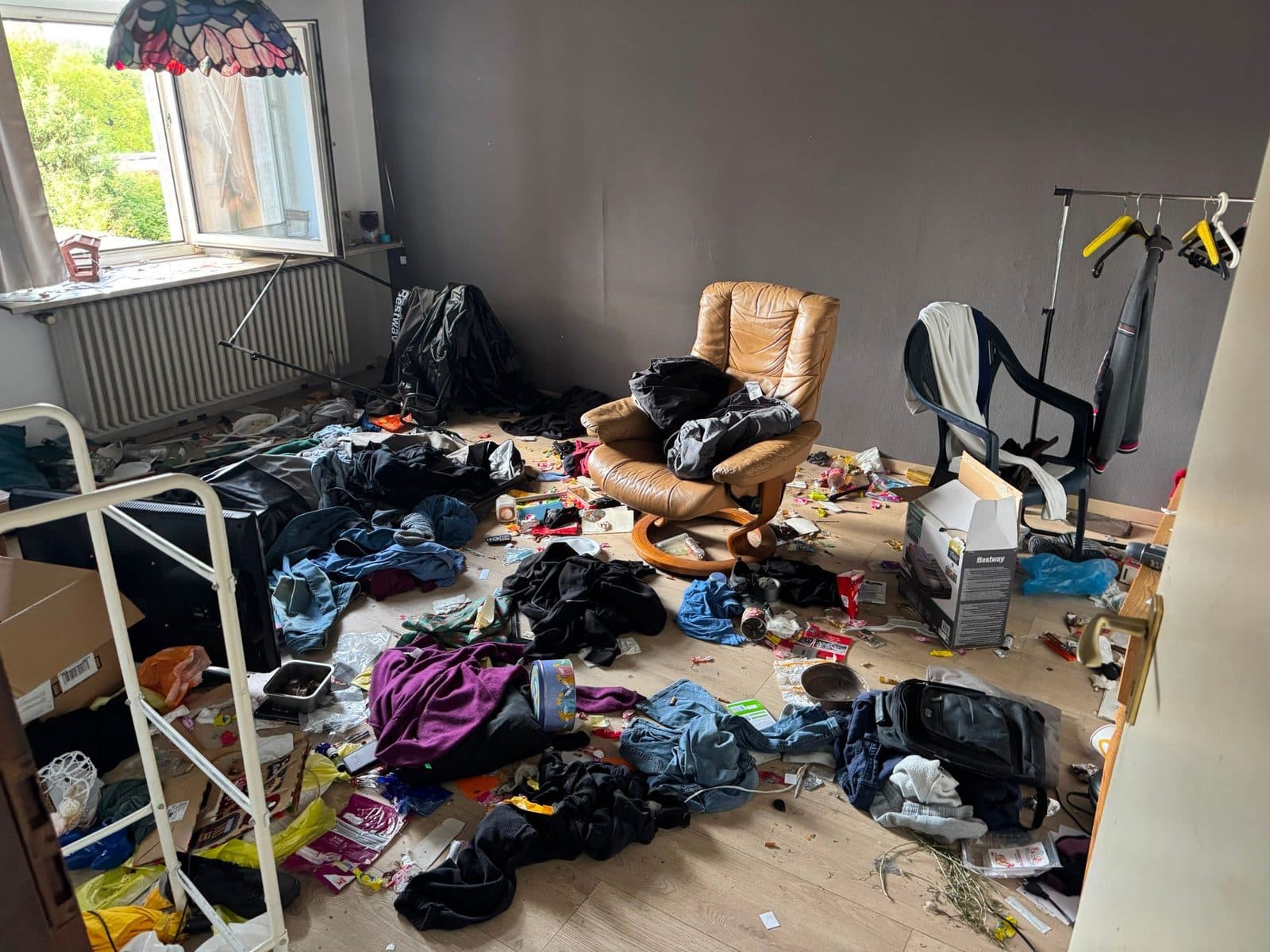 Stark vermülltes Zimmer mit Sessel in einer Wohnung in Duisburg vor der Räumung